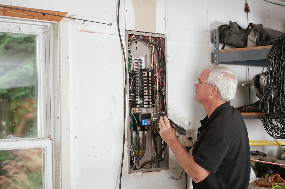 Electrician working inside a residential electrical service panel